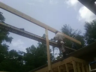Carpenter setting a ridge beam over a new addition frame — Ice Dam Removal by Roofing Brothers in Derby